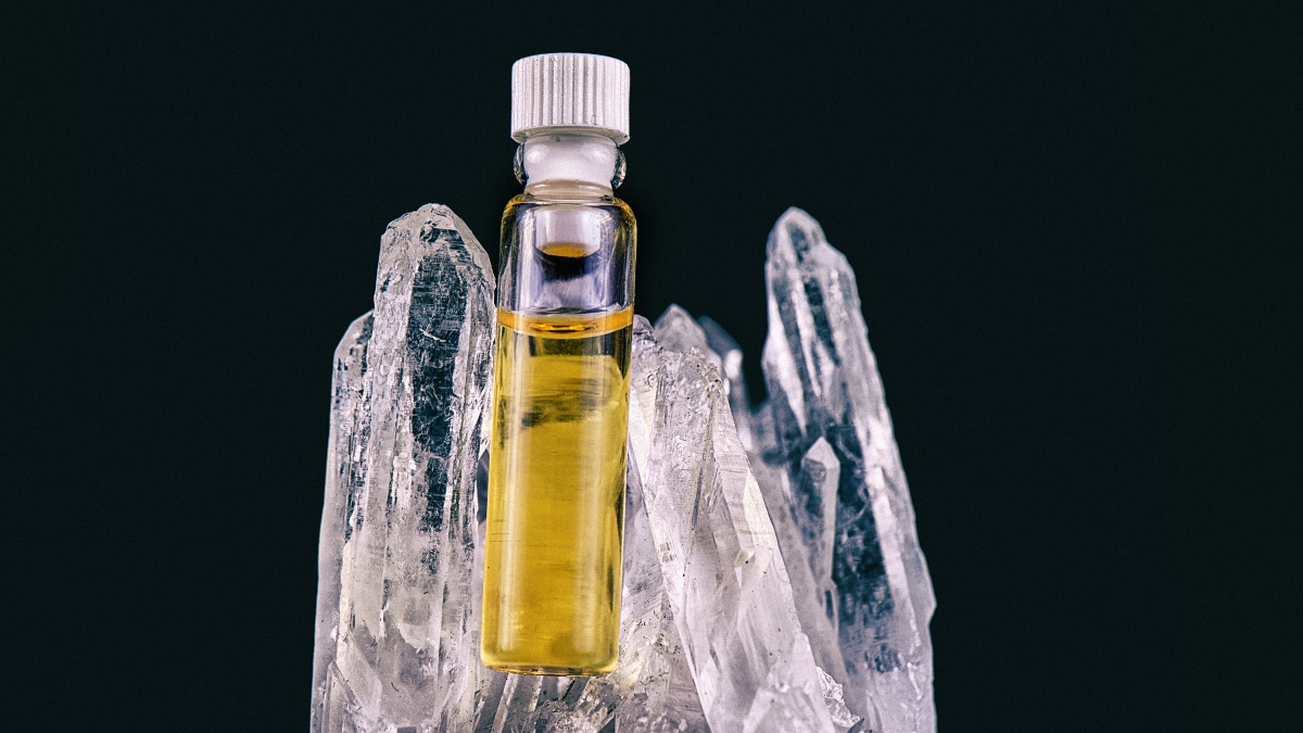 cbd oil inside a glass container surrounded by ice in a blcak background